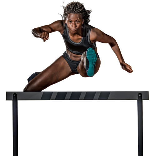 Female athlete jumping over a hurdle