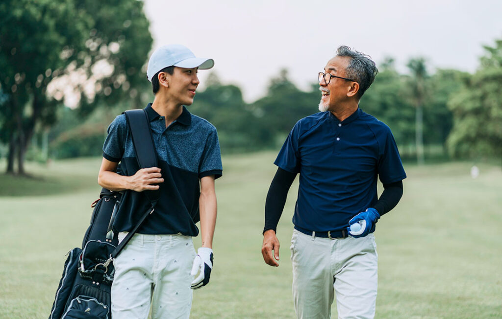 Older adult and teen on the golf course