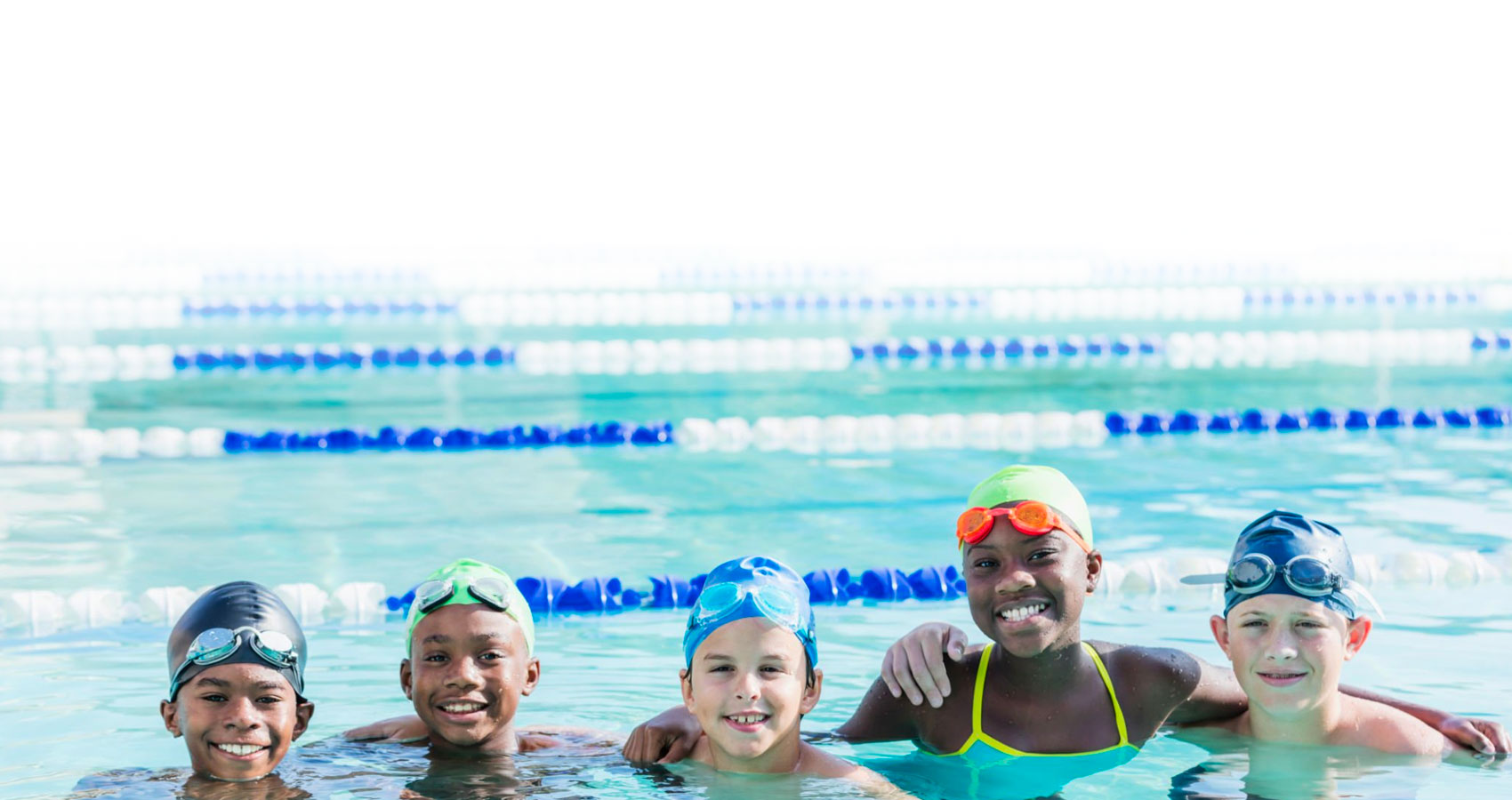 Multi ethnic group of children with swim caps and goggles at the swimming pool