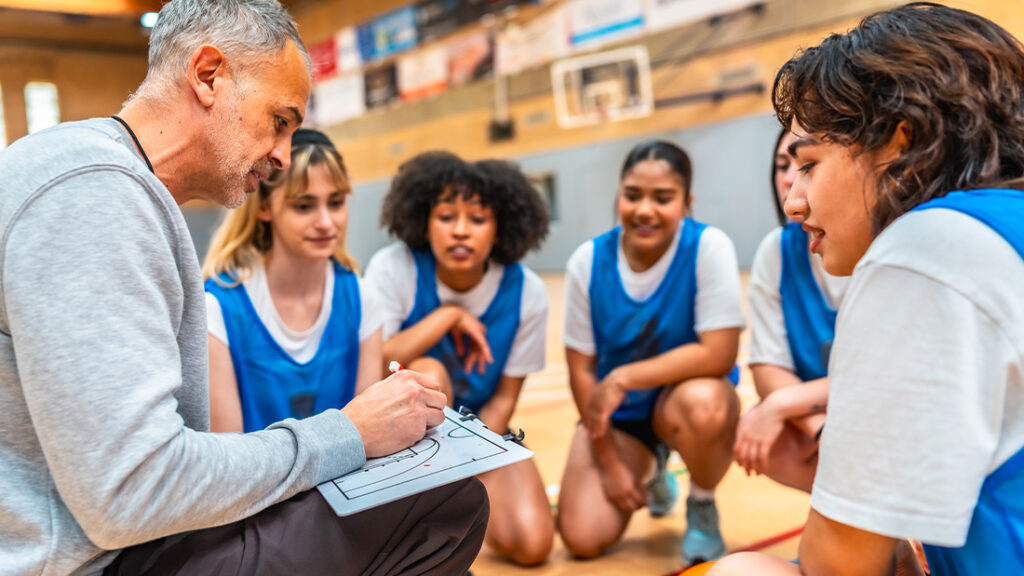 Basketball coach explaining game strategy to female team